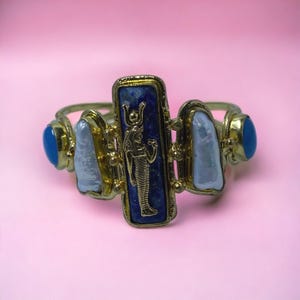 This Ancient Egyptian Isis charm features a Lapis Lazuli stone on a cuff bracelet embellished with 2 white pearls and 2 blue agate stones. image 8