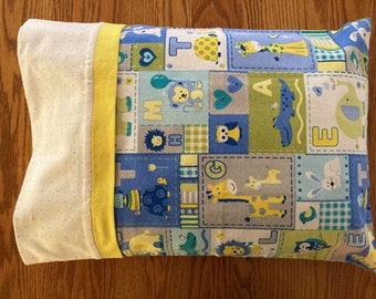 May include: A rectangular pillowcase with a white and yellow polka dot pattern on one side and a patchwork design on the other. The patchwork features blue, green, and gray squares with animal and letter illustrations. A yellow border frames the patchwork.