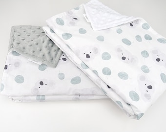 Puede incluir: Dos mantas para bebé, una con un patrón de puntos minky gris y la otra con un fondo blanco y un patrón repetido de caras de koala y hojas verdes. El texto "FANCAI" es visible en la manta gris.