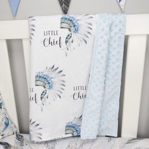Puede incluir: Una manta de beb&eacute; blanca con un patr&oacute;n de tocado azul y blanco y el texto "Little Chief" repetido. La manta se combina con una manta de minky azul claro.