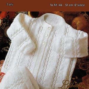 May include: White knitted baby matinee coat and bonnet set with a lacy pattern. The coat has a button closure and the bonnet has a bow. The set is made with 3 ply yarn and fits babies 46-51 cm (2 sizes).