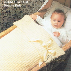 May include: A white waffle stitch cot or pram cover with a satin ribbon. The cover is 76 cm by 54.5 cm and is made with double knit.