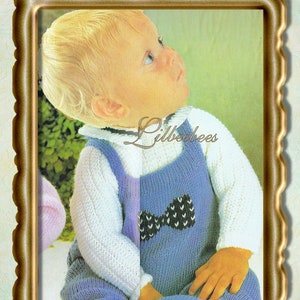 May include: A knitted baby outfit in blue and white. The outfit includes a blue dungaree with a white bow and a white long-sleeved jersey. The outfit is for a baby with a chest size of 46, 51, or 56 cm.