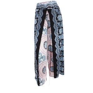 May include: Wide-leg pants with a unique design. The pants feature a black border with a blue and white elephant and floral pattern. The center panels have a pink and white circular design. The pants are made of a lightweight fabric.