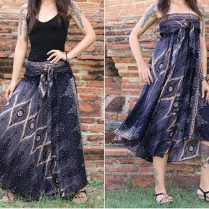 May include: A black and brown patterned maxi skirt with a wrap-around style and a brown belt. The skirt has a geometric design with a peacock feather motif.