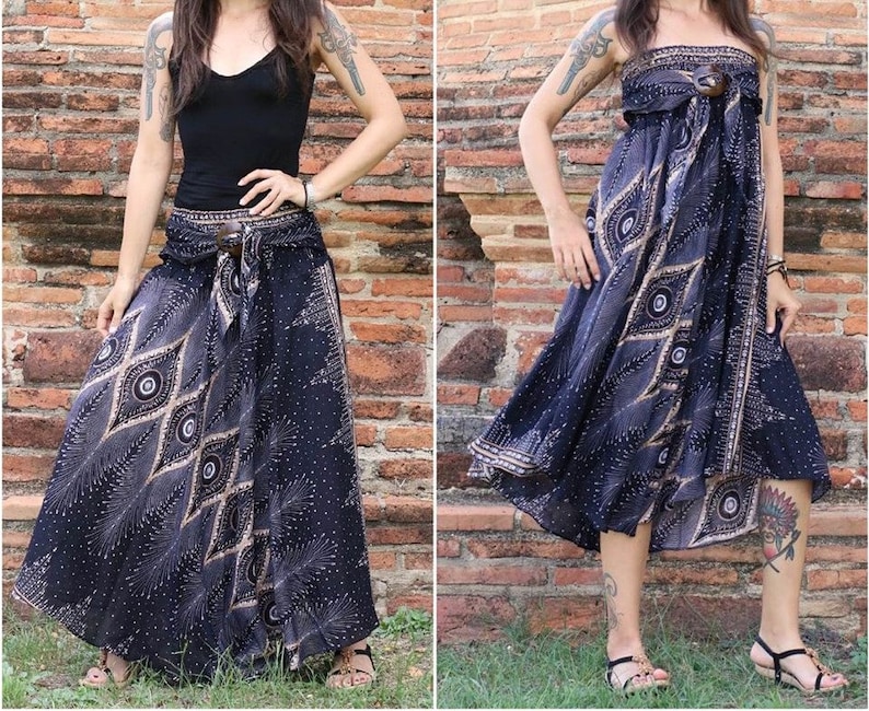 May include: A black and brown patterned maxi skirt with a wrap-around style and a brown belt. The skirt has a geometric design with a peacock feather motif.