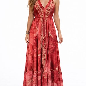 May include: A red halter maxi dress with a V-neck and a flowing skirt. The dress features a detailed floral pattern in shades of red and gold. It has a drawstring waist and decorative trim along the neckline and hem.