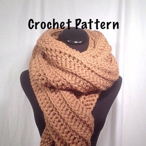 May include: A brown crocheted scarf with a textured pattern. The scarf is draped around a mannequin's neck. The text "Crochet Pattern" is written above the scarf.