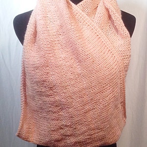 May include: A soft, peach-colored knitted scarf. The scarf is draped over a black mannequin.