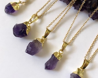 May include: Five gold chains with amethyst crystal pendants. Each pendant is a different size and shape, and they are all set in gold.