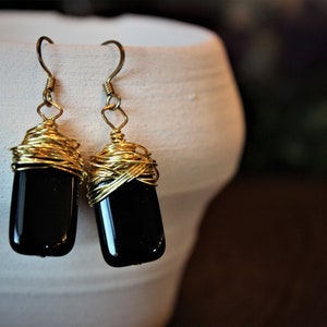 Black rectangular gold wire wrapped drop earrings.