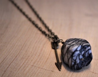 Collana pendente in pietra grigia con accento freccia e dettaglio nodo celtico