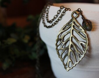 Gold skeletal leaf necklace, with olive / moss coloured, diamond shaped bead accent