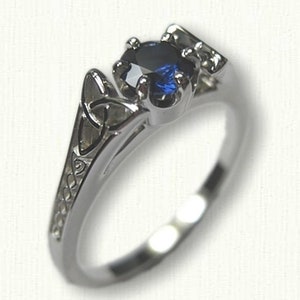 May include: A silver ring with a blue sapphire gemstone set in a Celtic knot design.