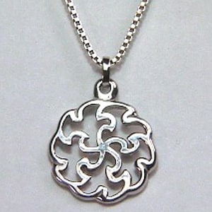 May include: A silver necklace with a delicate chain and a circular pendant featuring a swirling, intricate design.