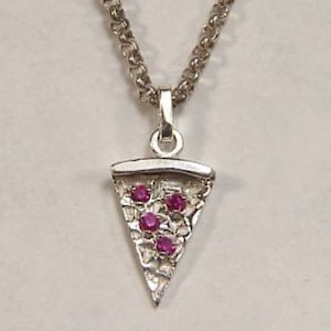Może przedstawiać: Srebrny naszyjnik z małym wisiorem w kształcie kawałka pizzy z pięcioma różowymi syntetycznymi rubinami.