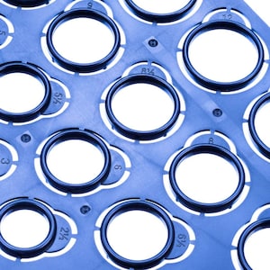 May include: A blue plastic template with circular cutouts of different sizes. Each cutout is labeled with a fraction, such as 3/4, 5/8, and 1/2.