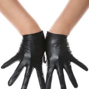 May include: A pair of black leather gloves with a smooth, semi-matte finish. The gloves feature a short wrist length, fitted construction, and visible stitching along the fingers and palms, providing a sleek and uniform appearance on both hands.