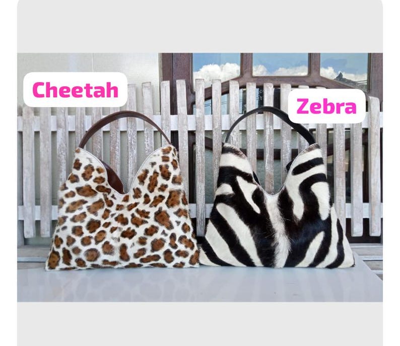 Puede incluir: Dos bolsos de estilo hobo con acabado de pelo texturizado. El bolso de la izquierda presenta un estampado de guepardo en marr&oacute;n y crema con asa marr&oacute;n. El de la derecha muestra un patr&oacute;n de rayas de cebra en blanco y negro con asa negra. Texto Cheetah y Zebra.