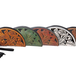 May include: Five half-moon shaped leather purses with floral tooled designs. The purses are in different colors: orange, green, brown, white, and black.