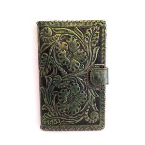 May include: A green leather wallet with a floral embossed design. The wallet has a flap closure with a snap button.