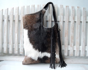 Bolso tote de piel con pelo, blanco y negro, detalles tejidos a mano, borlas.
