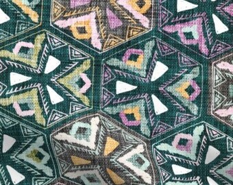 May include: A teal fabric with a repeating geometric pattern of pink, yellow, and white hexagons. The pattern is reminiscent of a traditional textile design.