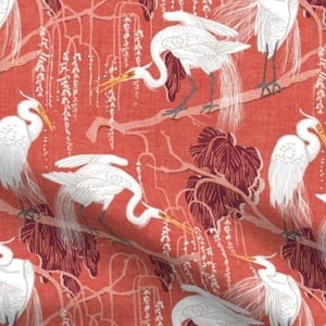 May include: A coral red fabric with a repeating pattern of white herons and white wisteria flowers. The herons are depicted in a stylized art deco style.
