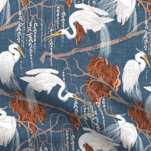 May include: A blue fabric with a repeating pattern of white herons and brown branches. The herons are depicted in a stylized, almost graphic, manner. The branches are stylized to look like willow branches with white blossoms.