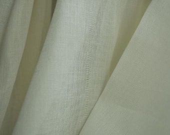 May include: A close-up of a sheer white fabric with a subtle woven texture. The fabric is soft and delicate, with a slightly translucent appearance.