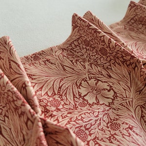 May include: Red fabric with a white floral pattern. The fabric is pleated and has a soft, flowing texture.
