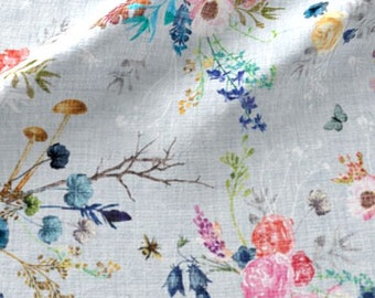 May include: A light blue fabric with a floral print featuring a variety of flowers, leaves, and butterflies in shades of pink, blue, yellow, and green.