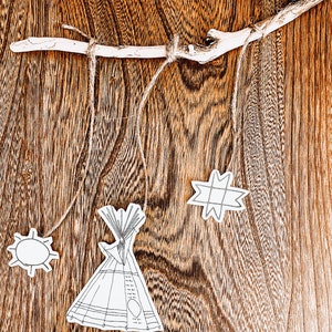 May include: A wooden branch with string attached to it. Hanging from the string are paper cutouts of a teepee, a star, and a sun.