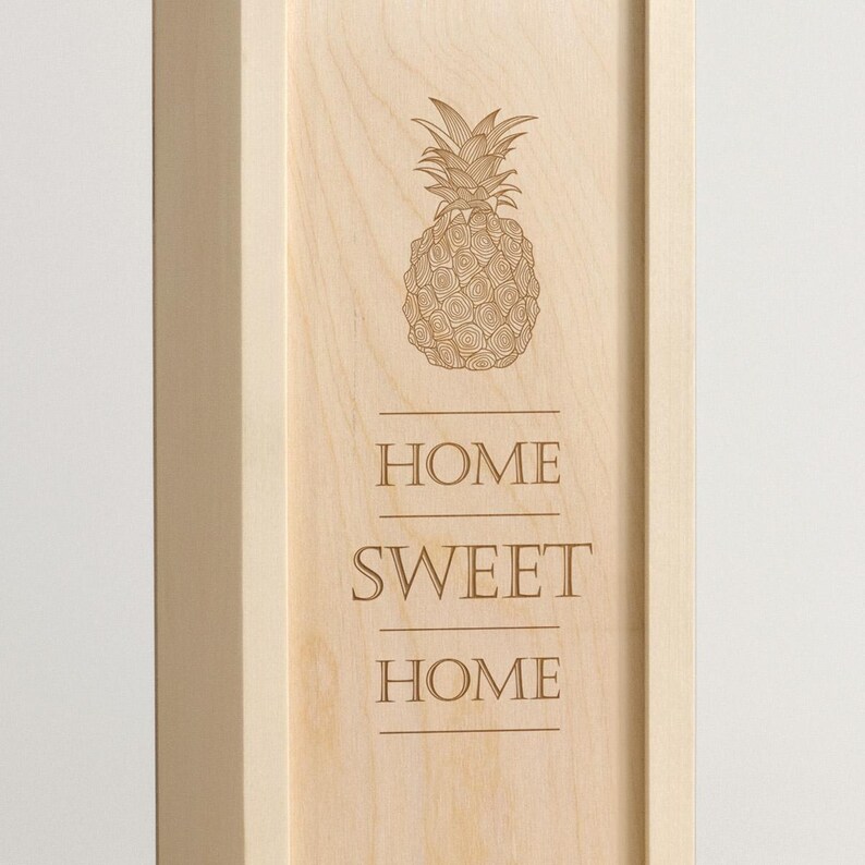 May include: A wooden sign with a pineapple design and the text "Home Sweet Home" engraved on it.