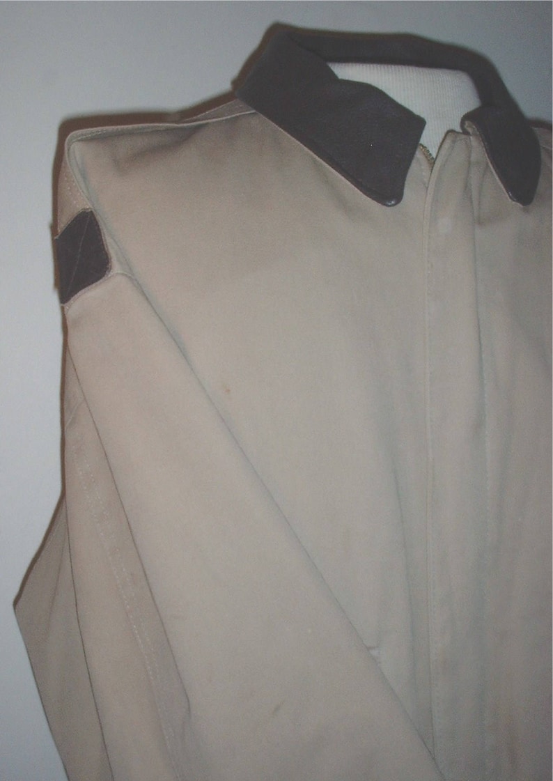 May include: A beige jacket with a brown corduroy collar and a brown patch on the left shoulder.