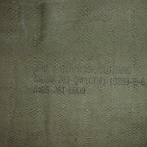 May include: A green canvas bag with the text "U.S. Army Clothing Size 36 (cm) 10289-E-64 6465-261 6909" printed on it.