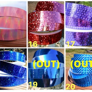 May include: A selection of decorative tapes in various colours and patterns. Includes pink iridescent, red heart-patterned, purple heart-patterned, blue glitter, solid blue, and blue diamond-patterned tapes. Each tape is labelled with a number.