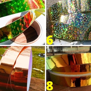 May include: Close-up of four rolls of decorative tape in various colours. The tape colours include green, gold, and copper. The tape is on a white roll. The tape is reflective and shiny.