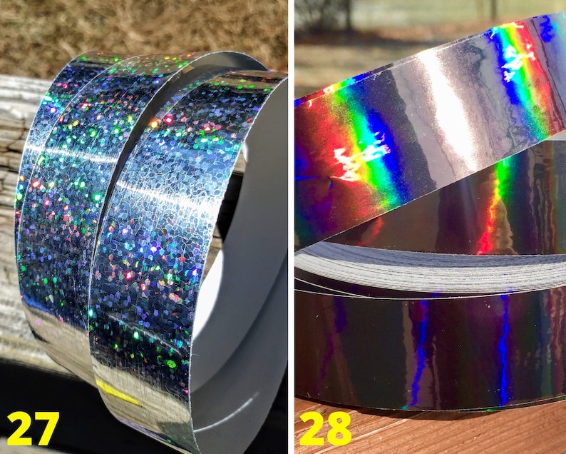 May include: Two rolls of silver holographic tape. One roll has a glittery, speckled appearance with multiple colours. The other roll has a smooth, reflective surface with a rainbow sheen. The numbers 27 and 28 are visible in the image.