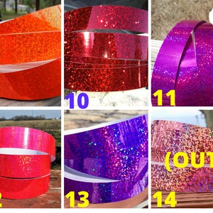 May include: A selection of glitter tape rolls in shades of orange, red, pink, purple, and blue. The tape is arranged in a circular shape, highlighting the glittery texture. The number 14 is labeled as "(OUT)".