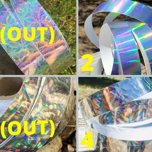 May include: Four rolls of holographic decorative tape. The tape has a silver, iridescent finish that reflects a rainbow of colours. The text "(OUT)" is visible on two of the rolls. The tape is likely used for crafts, scrapbooking, or gift wrapping.