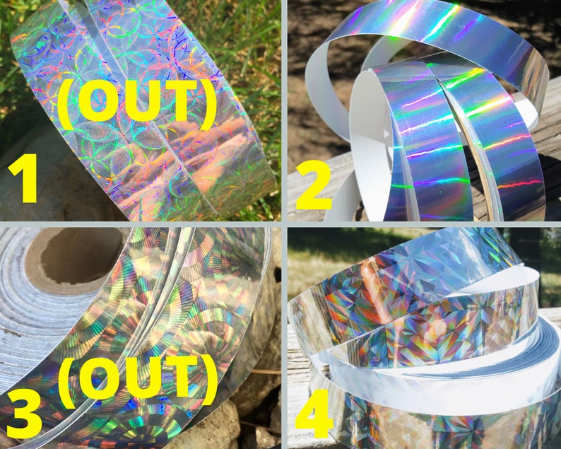 May include: Four rolls of holographic decorative tape. The tape has a silver, iridescent finish that reflects a rainbow of colours. The text "(OUT)" is visible on two of the rolls. The tape is likely used for crafts, scrapbooking, or gift wrapping.