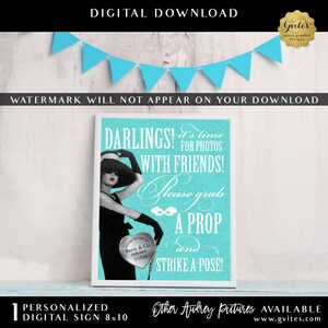 May include: A rectangular digital sign featuring a turquoise background with white text that reads: DARLINGS! it's time FOR PHOTOS WITH FRIENDS! Please grab A PROP AND STRIKE A POSE! An illustration of a person in a black dress and hat is included.
