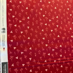 May include: Red fabric with a repeating pattern of white flowers and bees. The fabric is labeled "Sewcial Bee Collective" and "100% Premium Cotton". The text "Feel the Difference" and "artgalleryfabrics.com" are also visible.