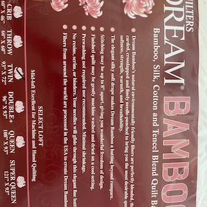 May include: A package of Dream Bamboo quilt batting, a blend of bamboo, silk, cotton, and Tencel. The packaging is a deep burgundy color with white text and pink floral accents. Sizes range from 46" x 36" to 122" x 120".