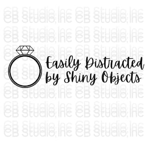 Puede incluir: Gráfico en blanco y negro con un anillo de diamantes y la frase "Easily Distracted by Shiny Objects" en cursiva. El diseño está sobre un fondo blanco.