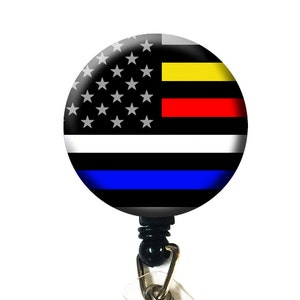 May include: A black and blue retractable badge holder with a round, white, red, yellow, and blue American flag design.