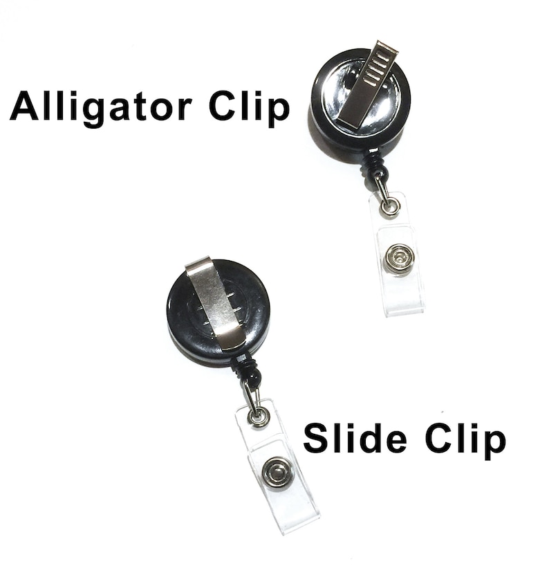 May include: Two black retractable badge holders with different clip styles. The top holder has an alligator clip and the bottom holder has a slide clip. Both holders have clear plastic straps.