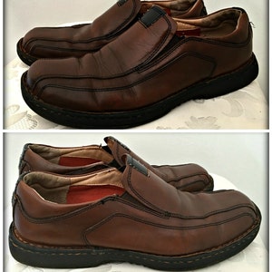 May include: A pair of brown leather slip-on shoes with a black rubber sole. The shoes have a slightly distressed look and are made of a high-quality leather.