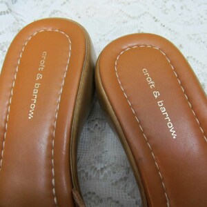 May include: A pair of brown leather sandals with the text "croft & barrow." printed on the insole.